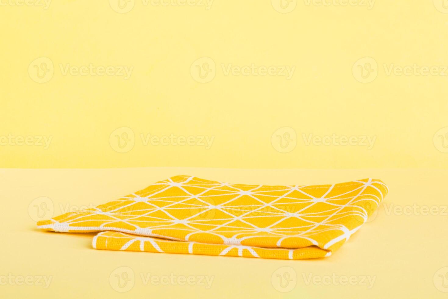 top view with yellow empty kitchen napkin isolated on table background. Folded cloth for mockup copy space, photo