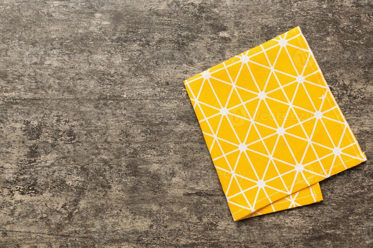 top view with yellow empty kitchen napkin isolated on table background. Folded cloth for mockup photo