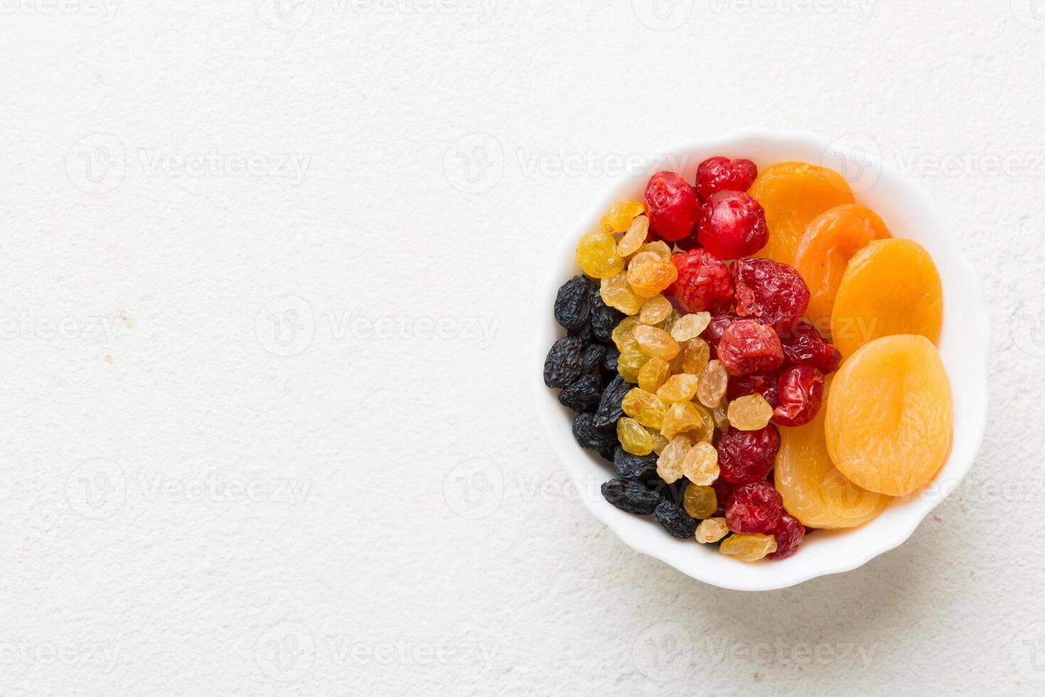 Bowl with different dried fruits on table background, top view. Healthy lifestyle copy space photo