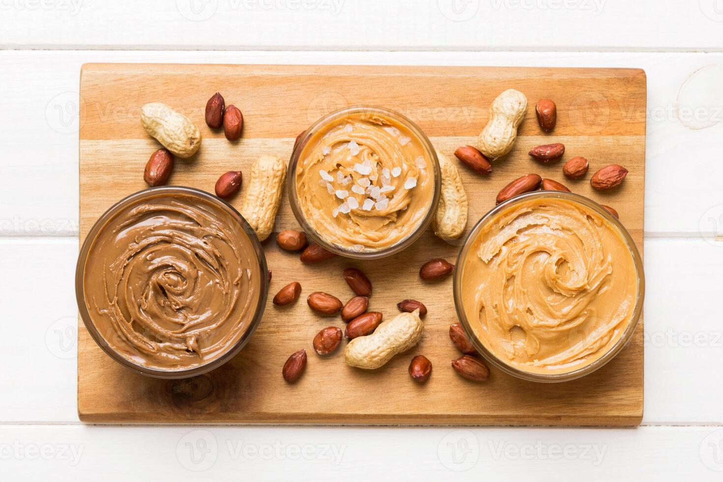 Glass jar with peanut butterin plate on table background, top view space text and close up photo