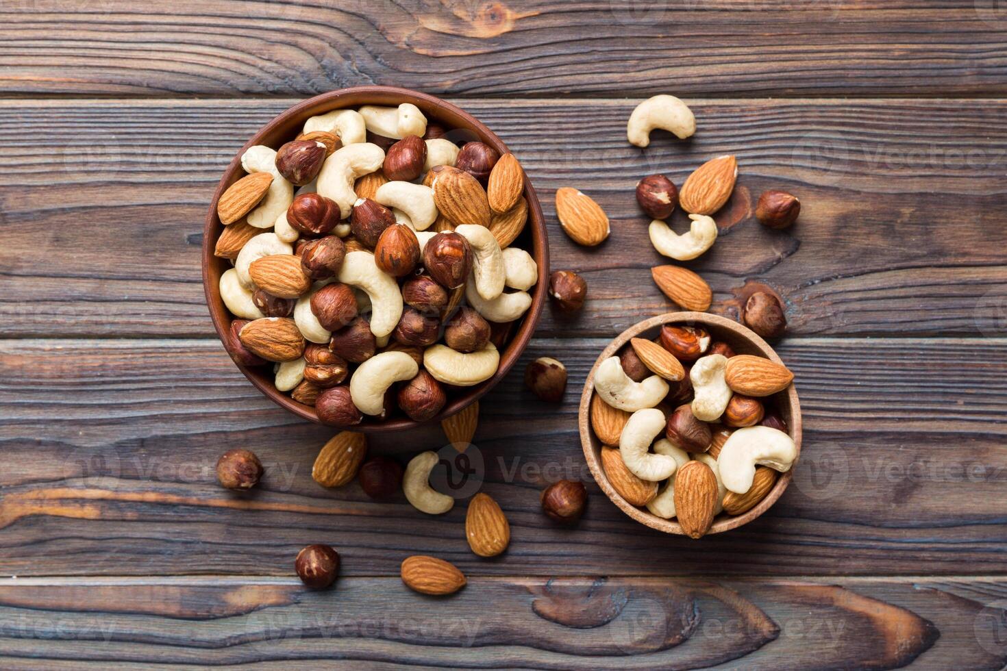 Assortment of nuts in wooden bowl on colored table. Cashew, hazelnuts, walnuts, almonds. Mix of nuts Top view photo