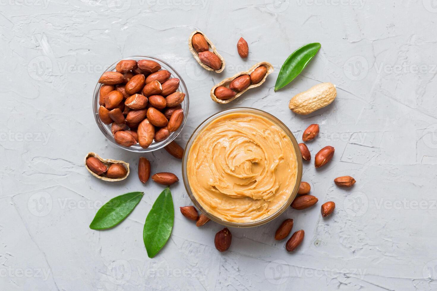 Bowl of peanut butter and peanuts on table. top view with copy space. Creamy peanut pasta in small bowl photo