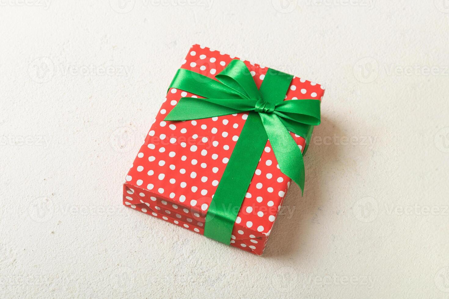 Wrapped christmas or other holiday handmade present in paper with colored ribbon. Present box, decoration of gift on table, top view photo