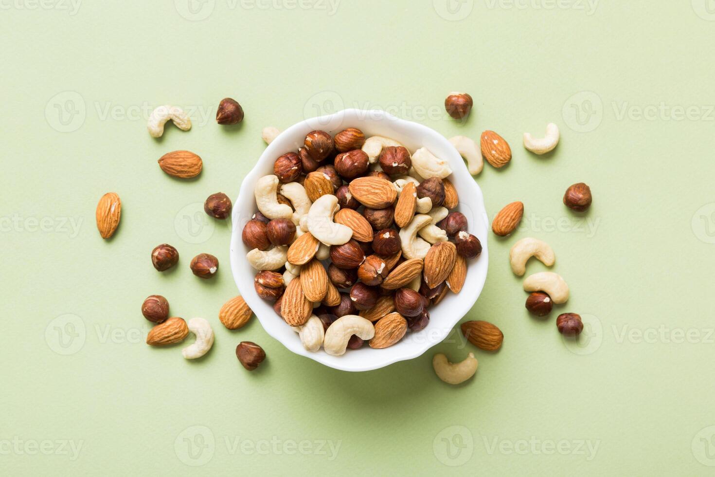 Assortment nuts wooden bowl on colored table. Cashew, hazelnuts, walnuts. Mix of nuts Top view with copy space photo