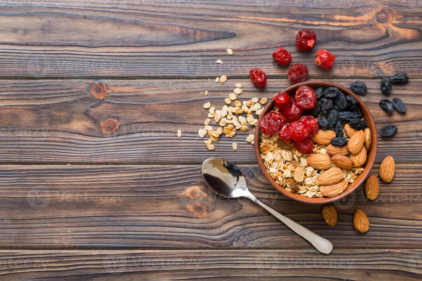 Cooking a wholesome breakfast. Granola with Various dried fruits and nuts in a bowl. The concept of a healthy dessert. top view with copy space photo
