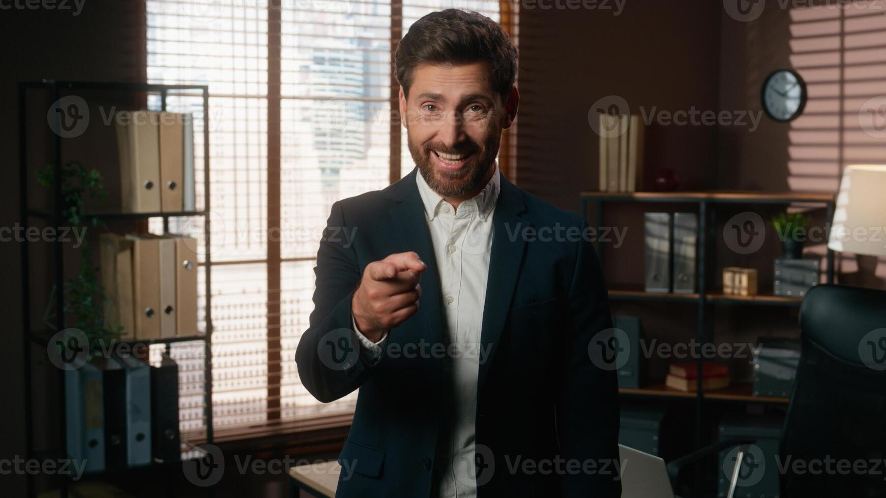Happy smiling man male recruiter mature businessman index finger hey you gesture pointing at wrist like wristwatch showing time late invite join business team office inviting come here welcome hiring photo