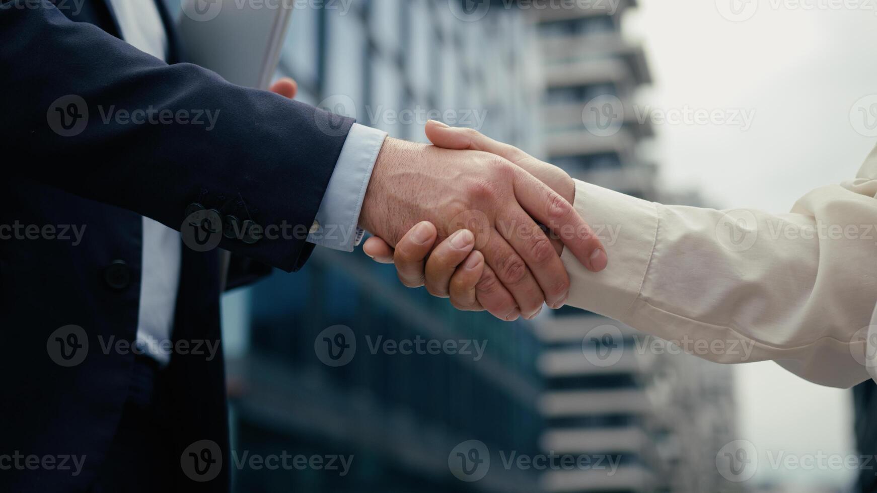 Two business people handshaking meeting in city businessman handshake with businesswoman partners diversity multiracial shaking hands cooperation man woman welcome hiring partnership success deal photo