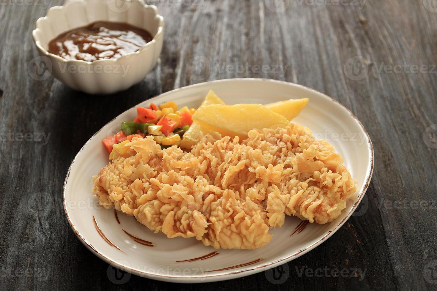 Crispy Chicken Steak with Potato Wedges, Sauted Vegetables, and Mushroom Sauce. photo