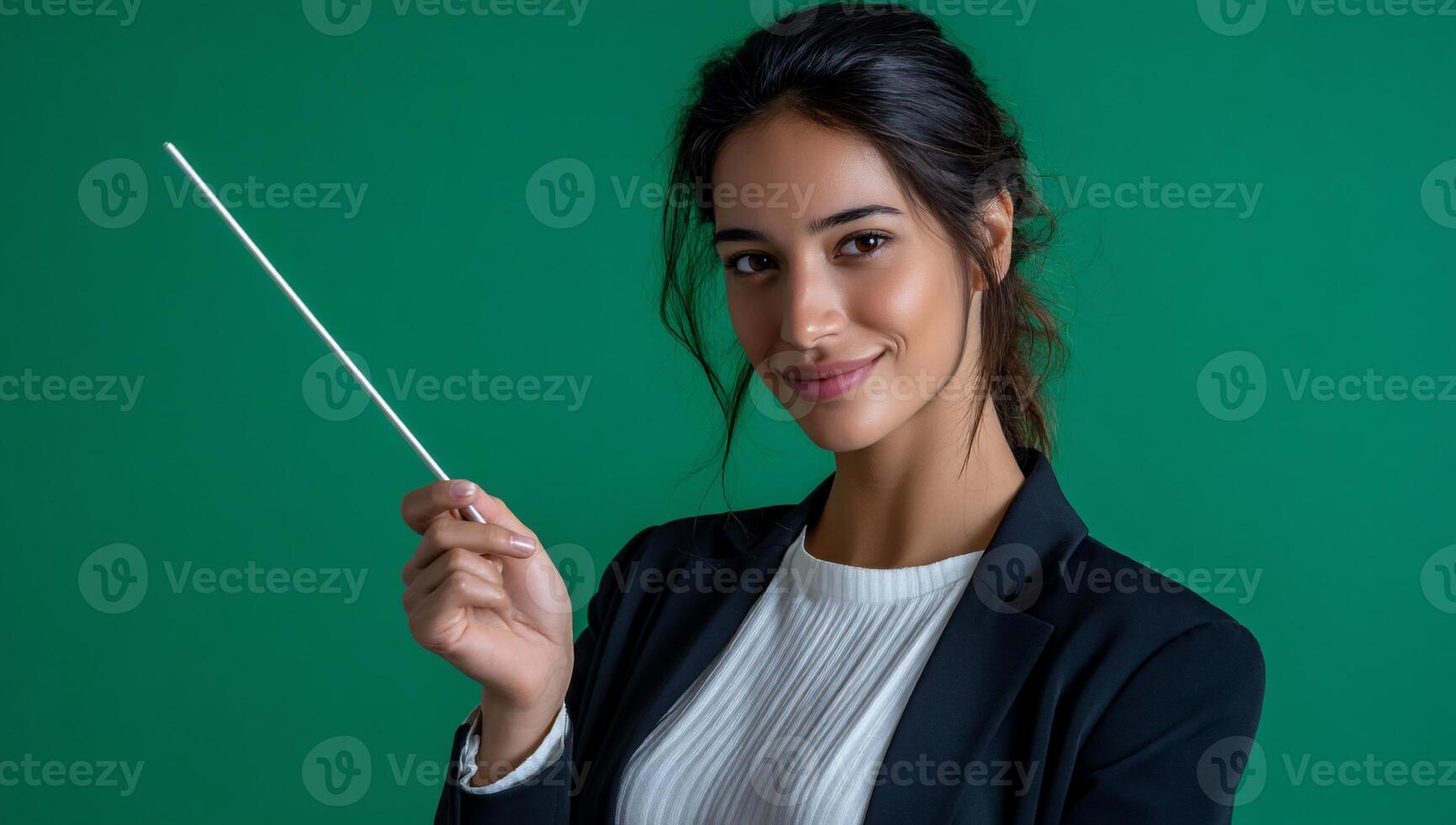 Woman in blazer, pointing with rod against green background photo