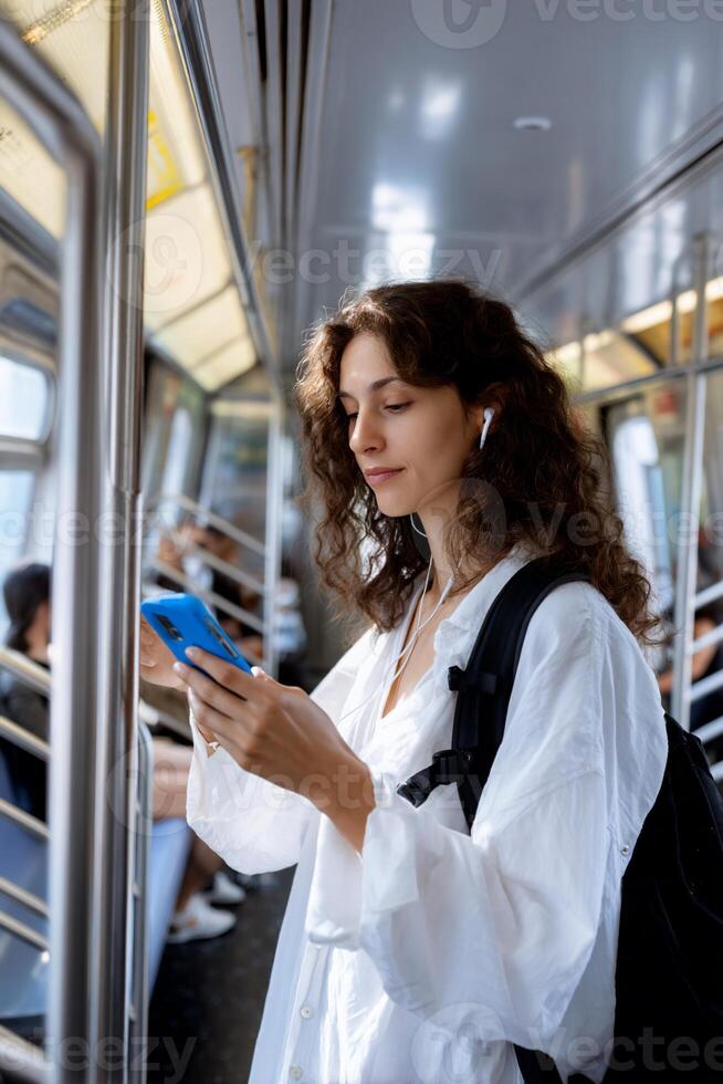 Woman on subway, using phone photo