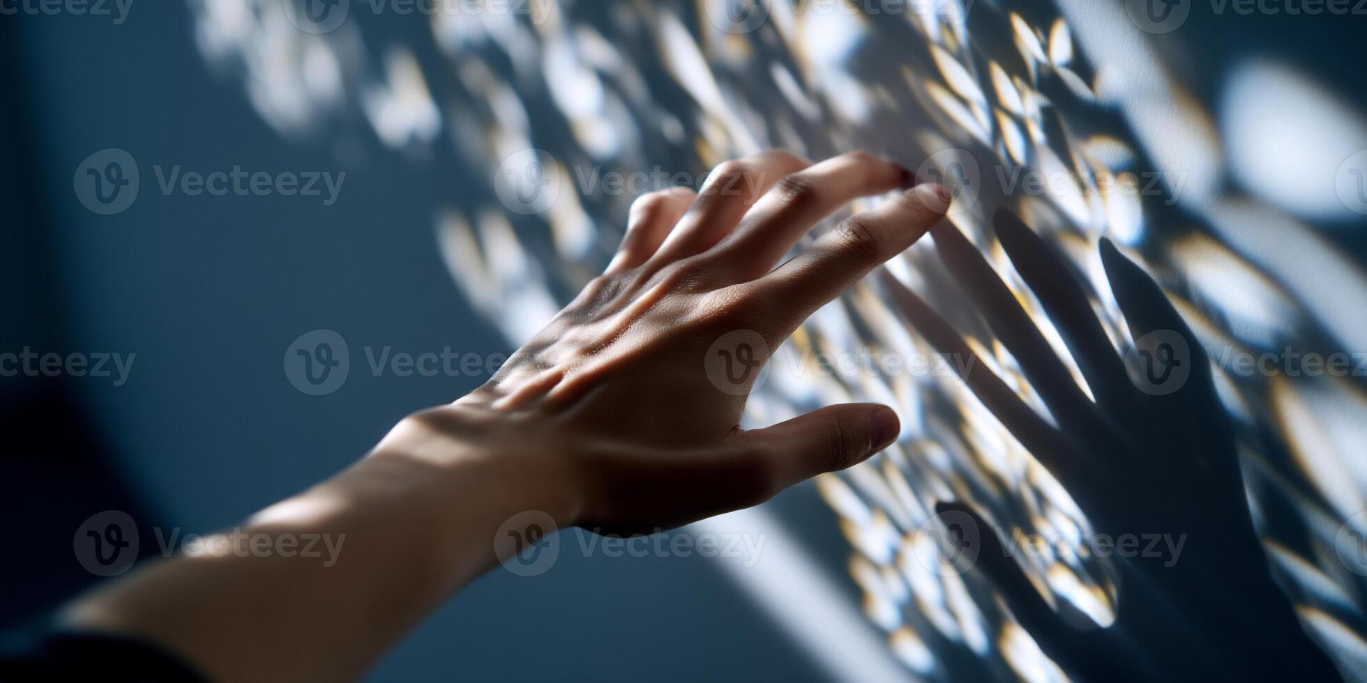 A hand reaching out to touch a wall with a shadow photo