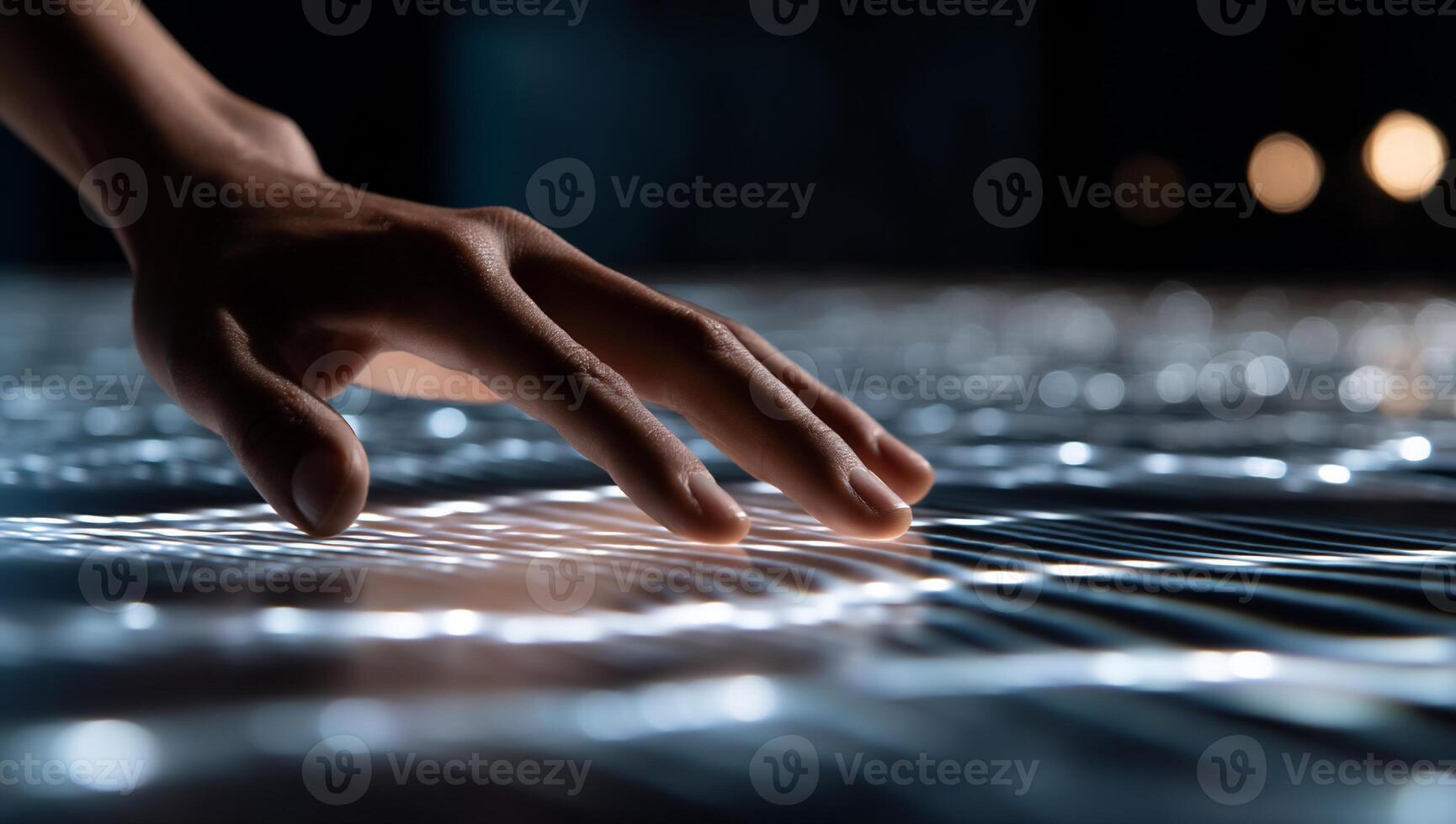 A person touching a surface with a glowing light photo