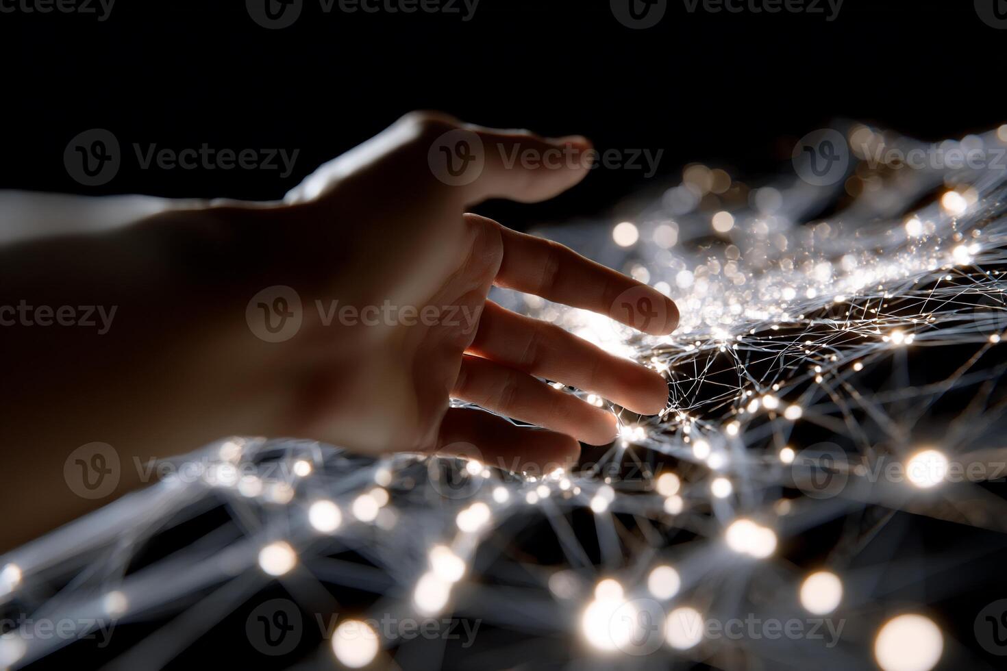 A hand reaching out to touch a network of lights photo