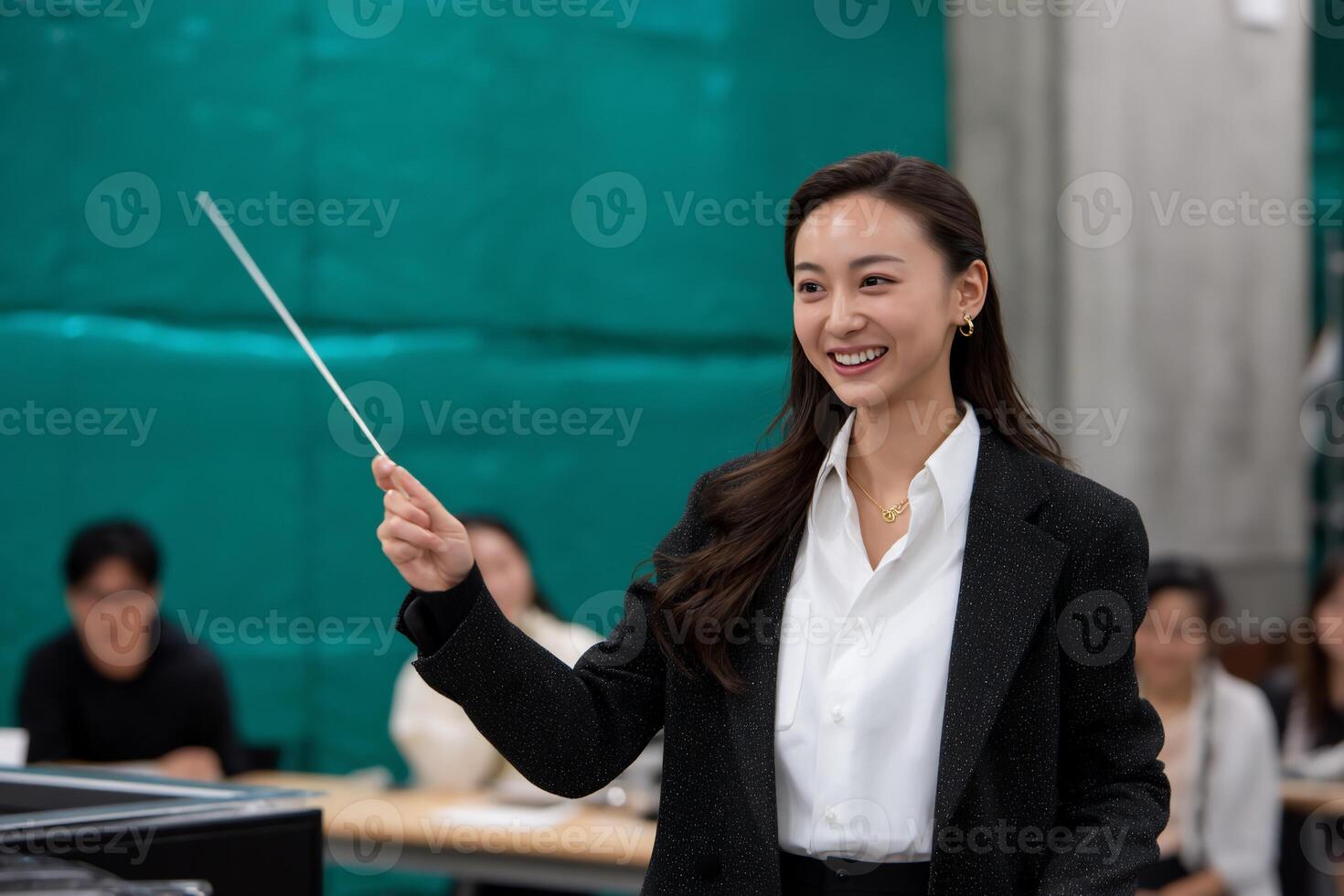 Woman conducting, smiling, in a classroom setting photo