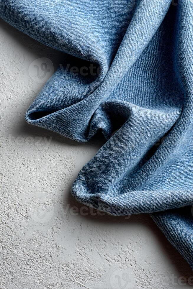 Draped denim fabric on textured surface photo