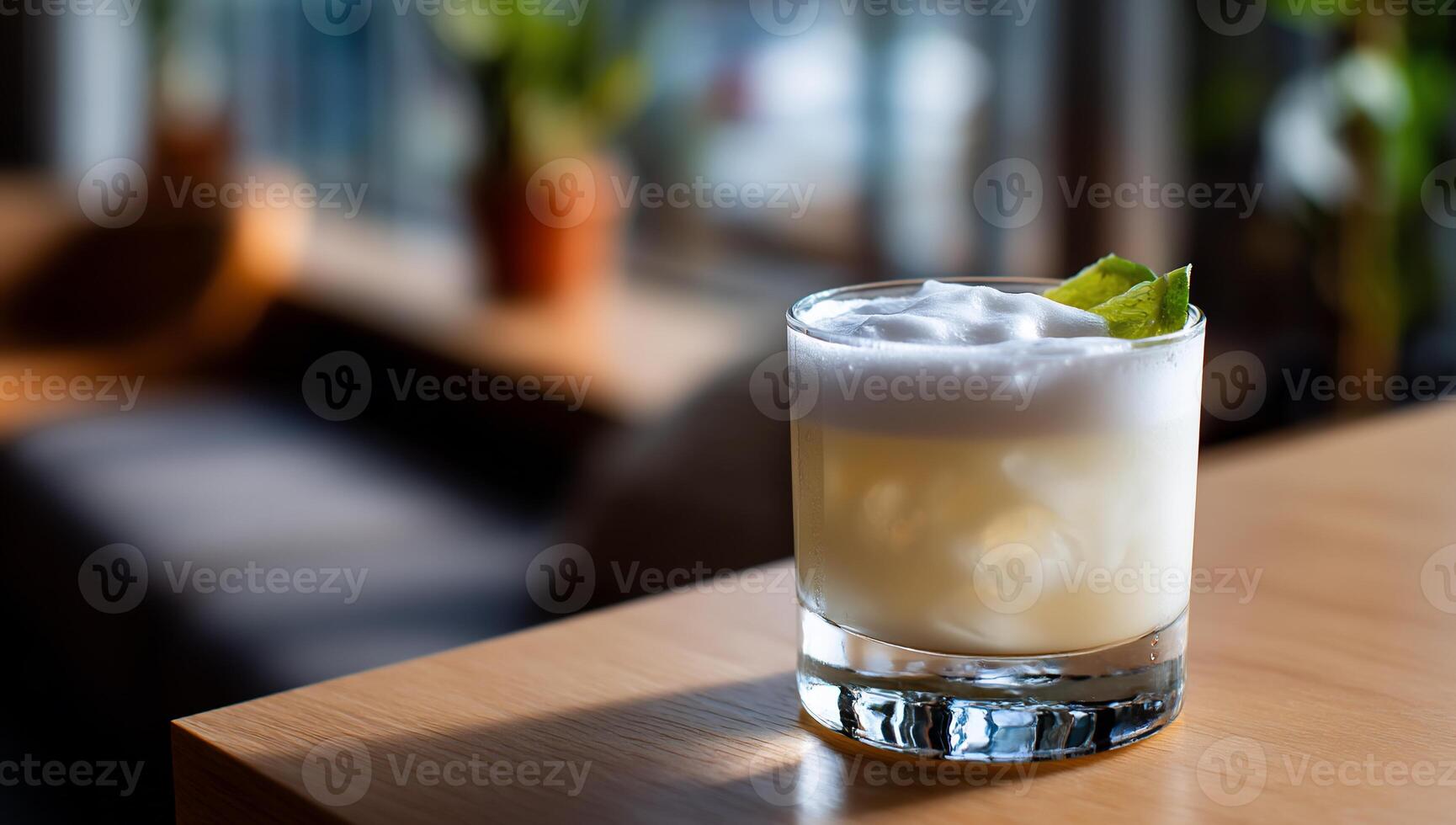 A light, frothy cocktail sits on a table photo
