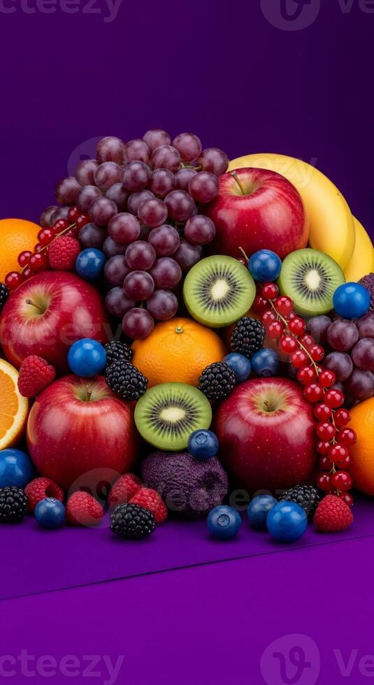 Vibrant fruit medley featuring apples, grapes, kiwi, and berries on a purple backdrop photo