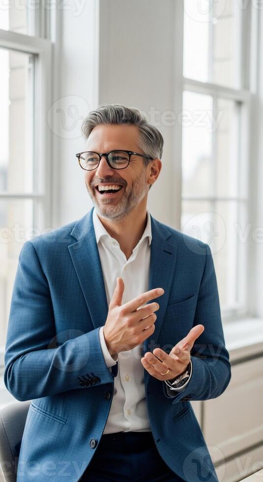 A man in a suit and glasses is talking to someone photo