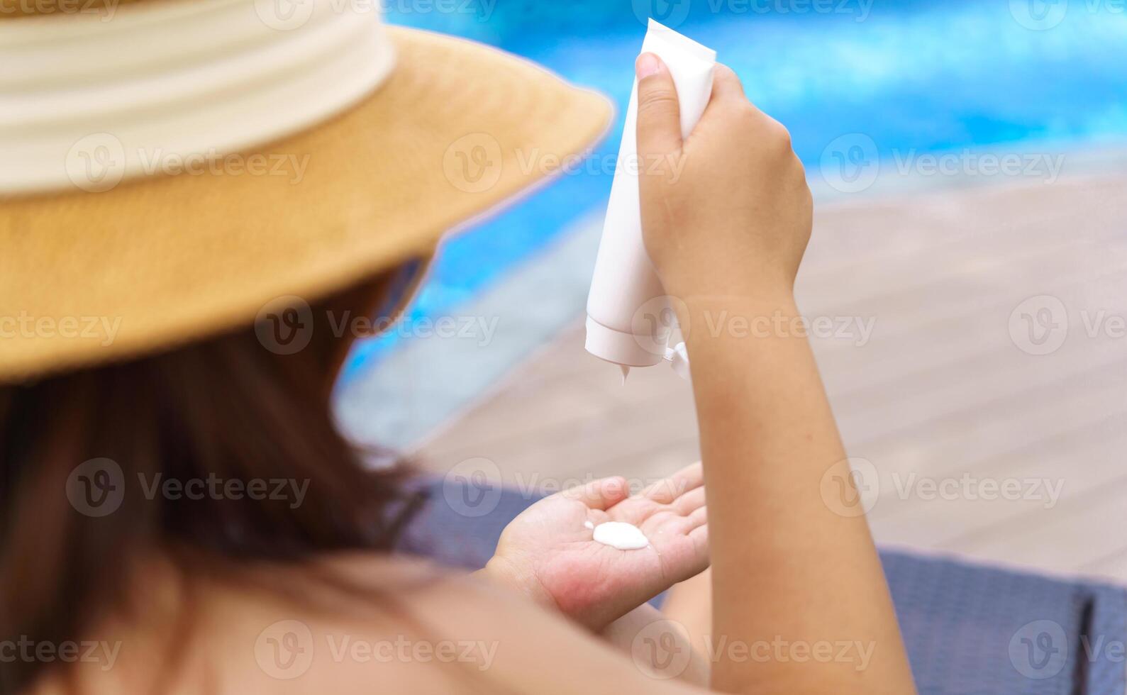 Obese Woman in a hat is applying sunscreen photo