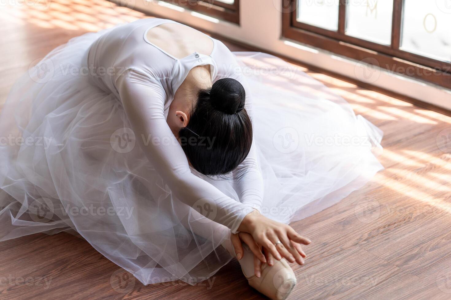 a woman in a white ballet sitting on the floor photo