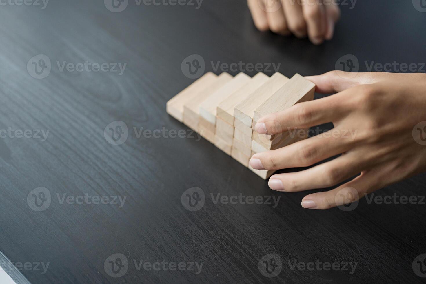 a person is placing wooden blocks on a table. photo