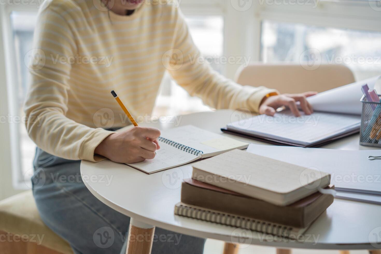 a woman sitting at a table with a notebook and pen photo