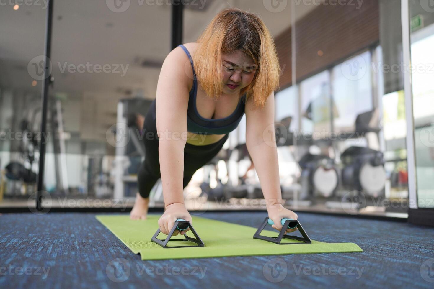 Overweight woman exercising for weight loss. plank exercise in stretching positions on mat yoga at gym Cheerful Fat woman diet healthy lifestyle. photo