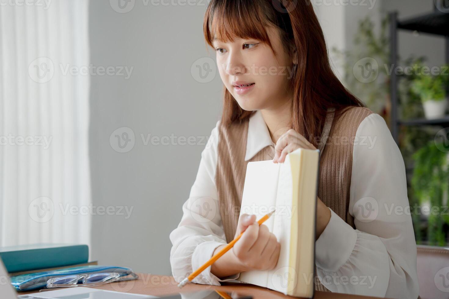 Asian woman using laptop to study engaged in online learning at college. photo