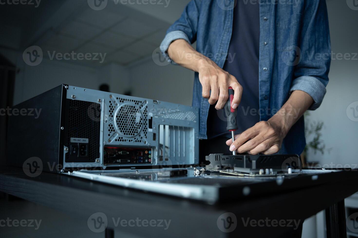IT Engineer installing Hardware working on a computer with a screwdriver photo