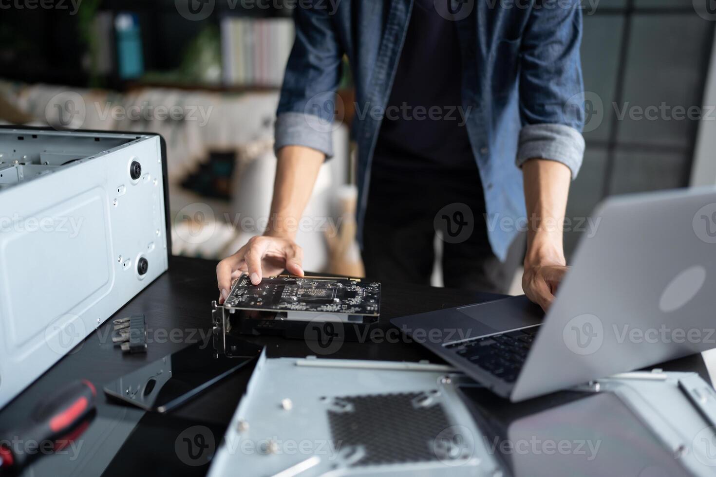 IT Engineer installing Hardware working on a laptop computer with a motherboard photo