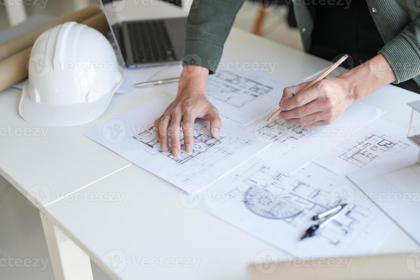 Architecture interior is working on blueprints with a hardhat photo