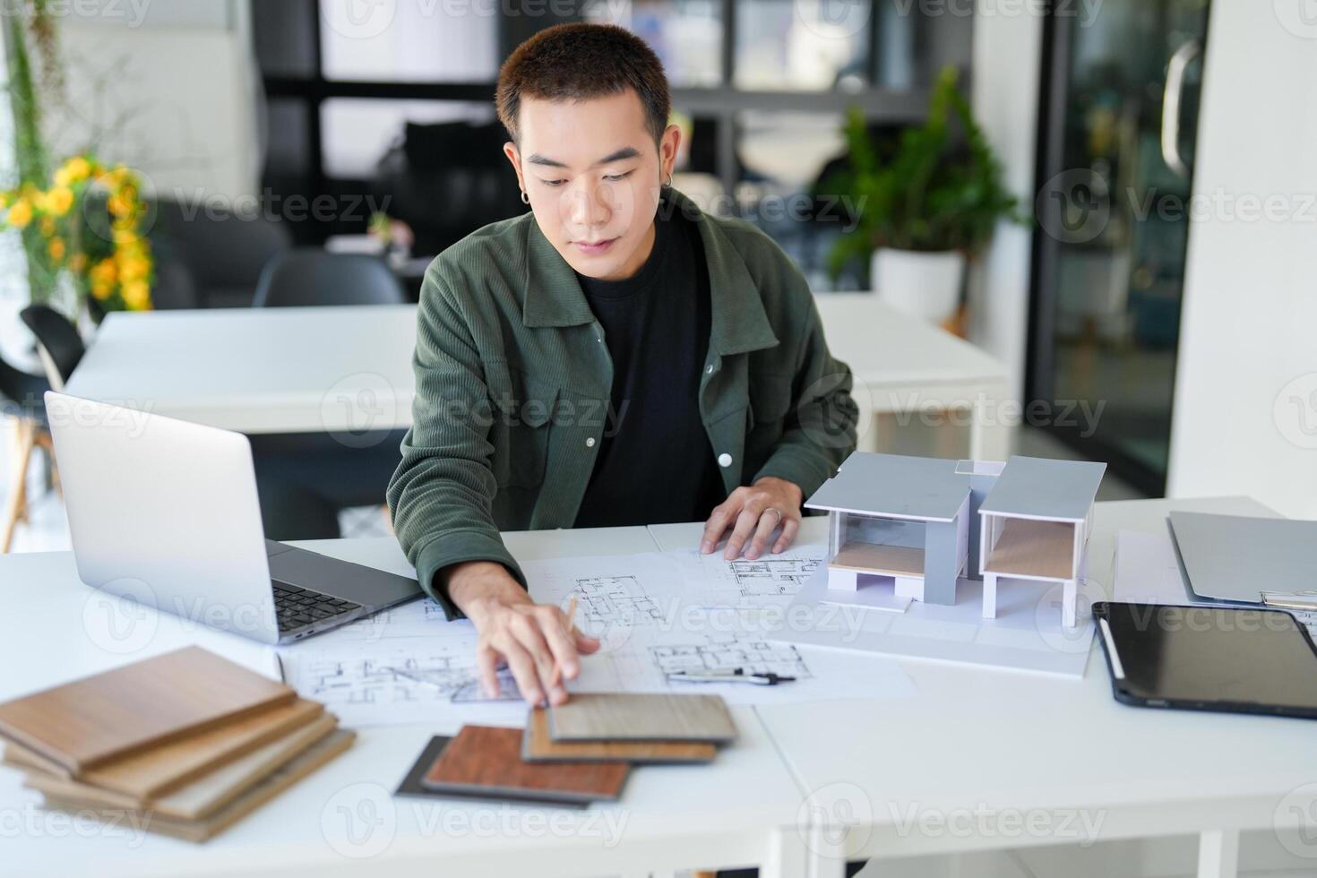 a man is working on a project at a desk. photo