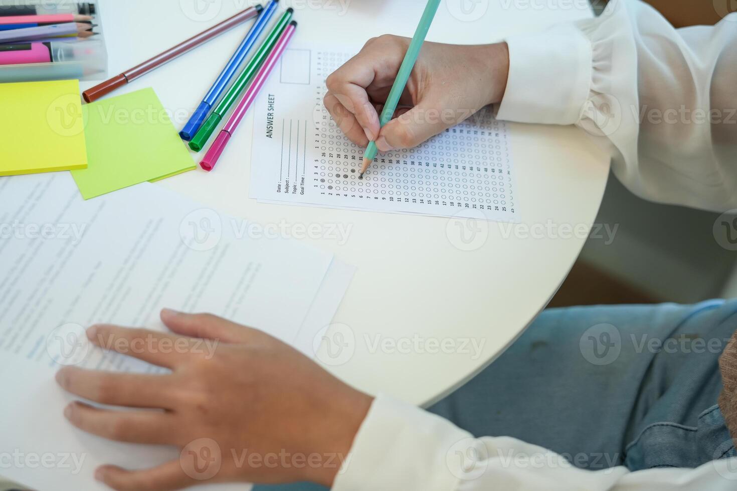girl student reading book preparing for college exam Young female student studying and writing on notebook making in school library photo