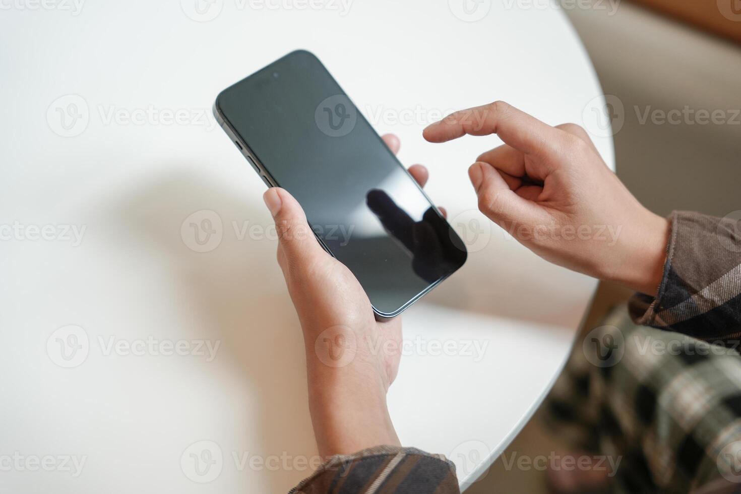 a person holding a smartphone with a finger on the screen photo