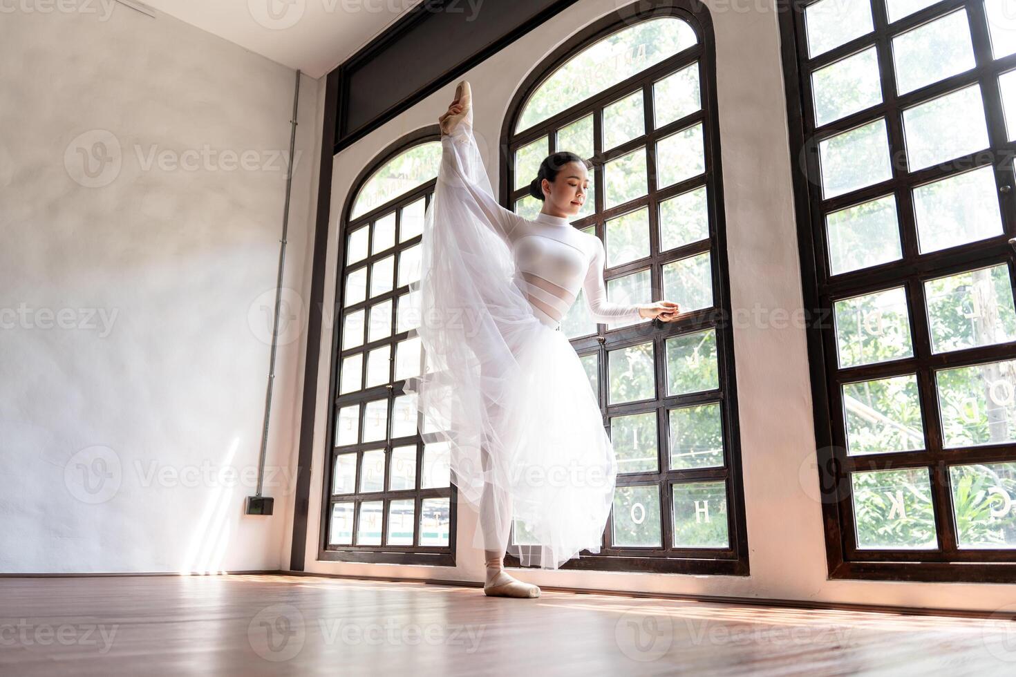 a woman in a white dress is standing in front of a window photo