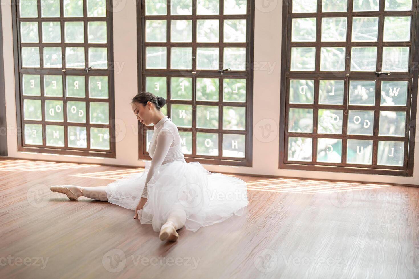 a woman in a ballet outfit sitting on the floor photo