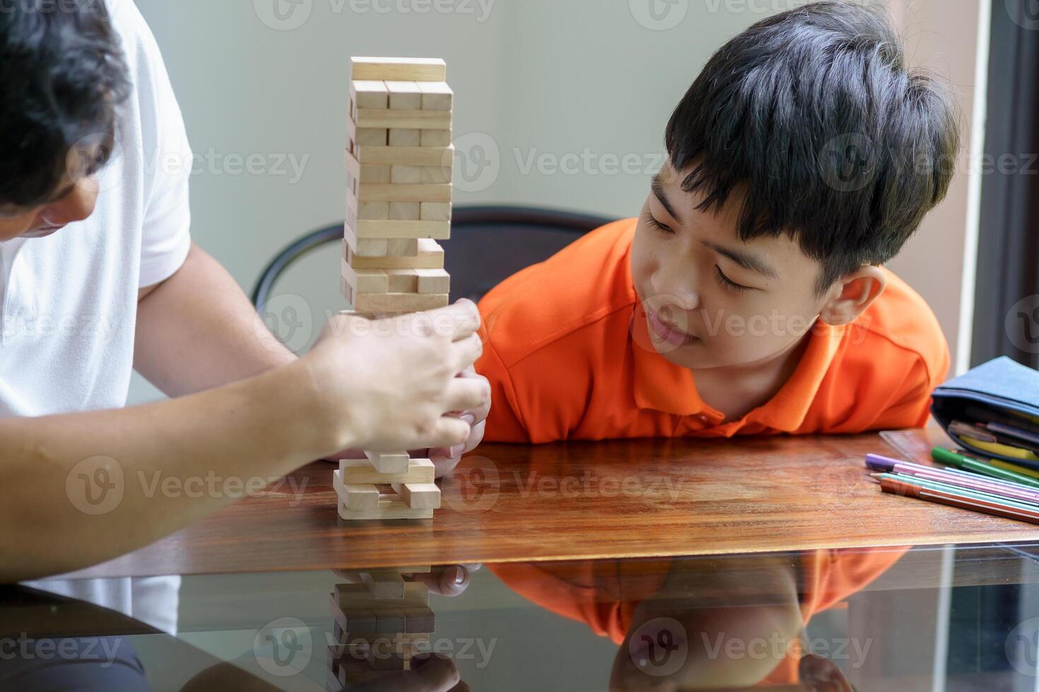 a man and boy playing with wooden blocks on a table photo