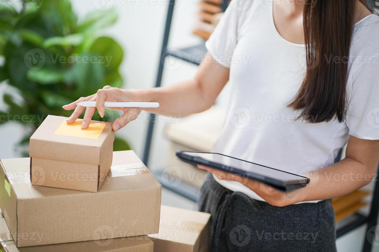 Business Home Asian woman preparing package delivery box Shipping for shopping online. young start up small business owner at home. photo