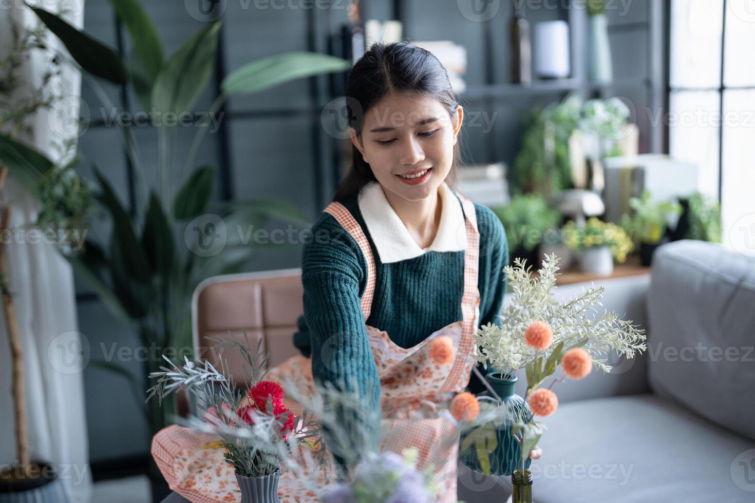 Sporty Happy asian Woman arranging flowers caring for home greenery photo