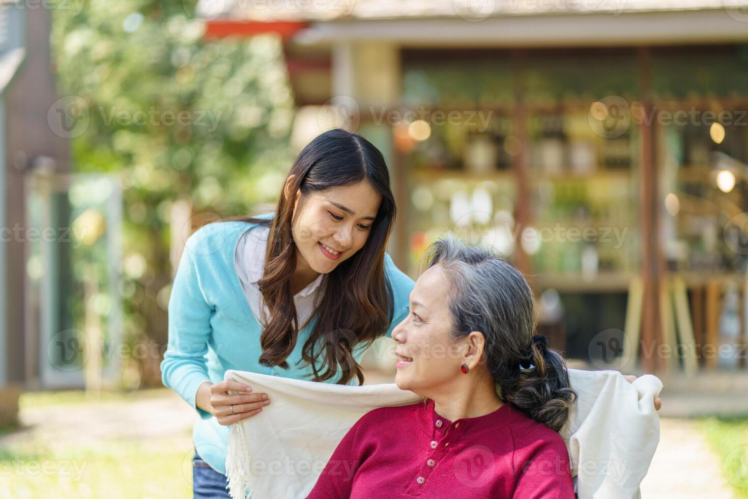 Asian senior woman in wheelchair with happy daughter. Family relationship retired woman sitting on wheelchair in the park age care at retirement home photo