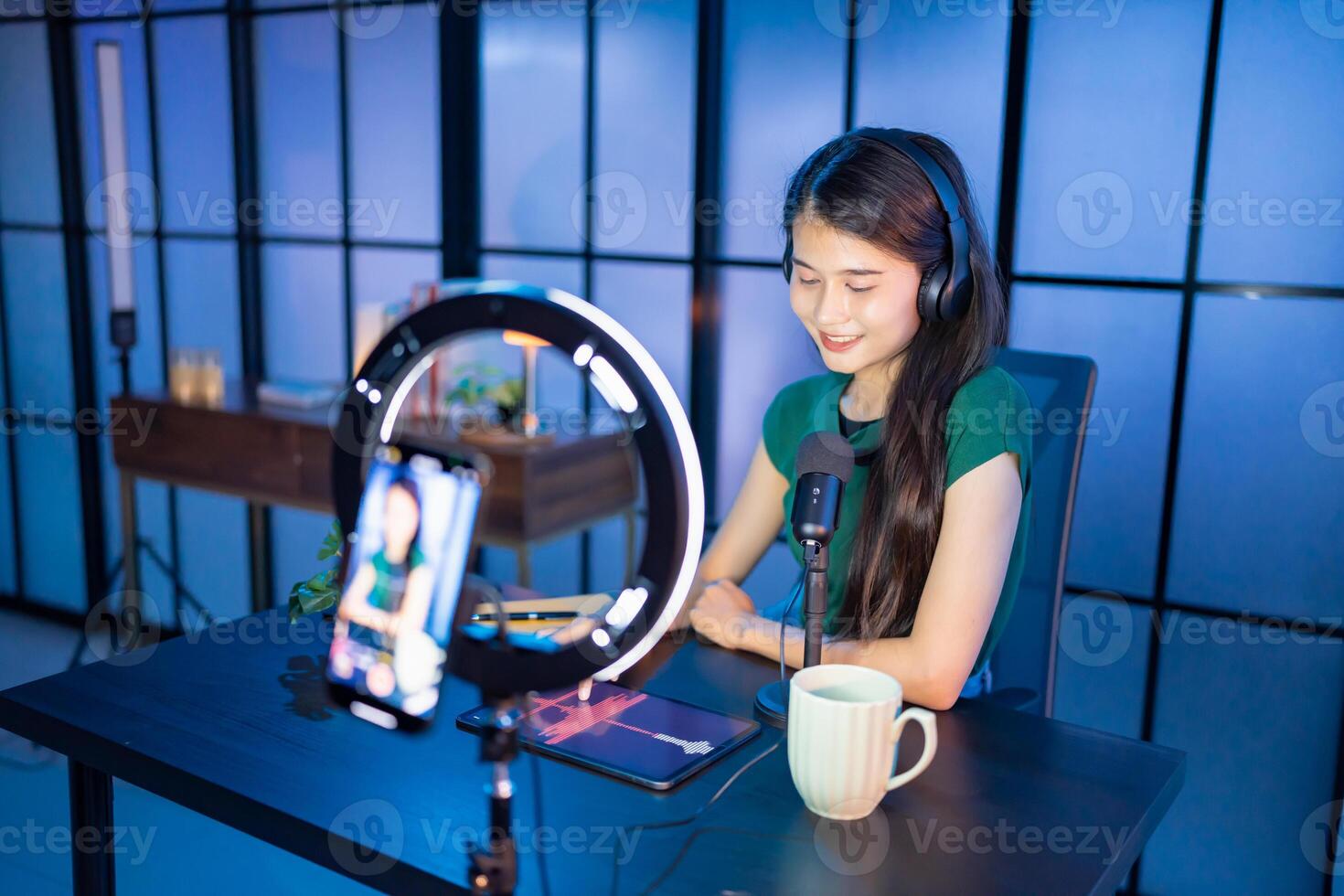 Content creator Young asian woman influencer creating content in home studio entertainment and communication blogger vdo record with smartphone photo