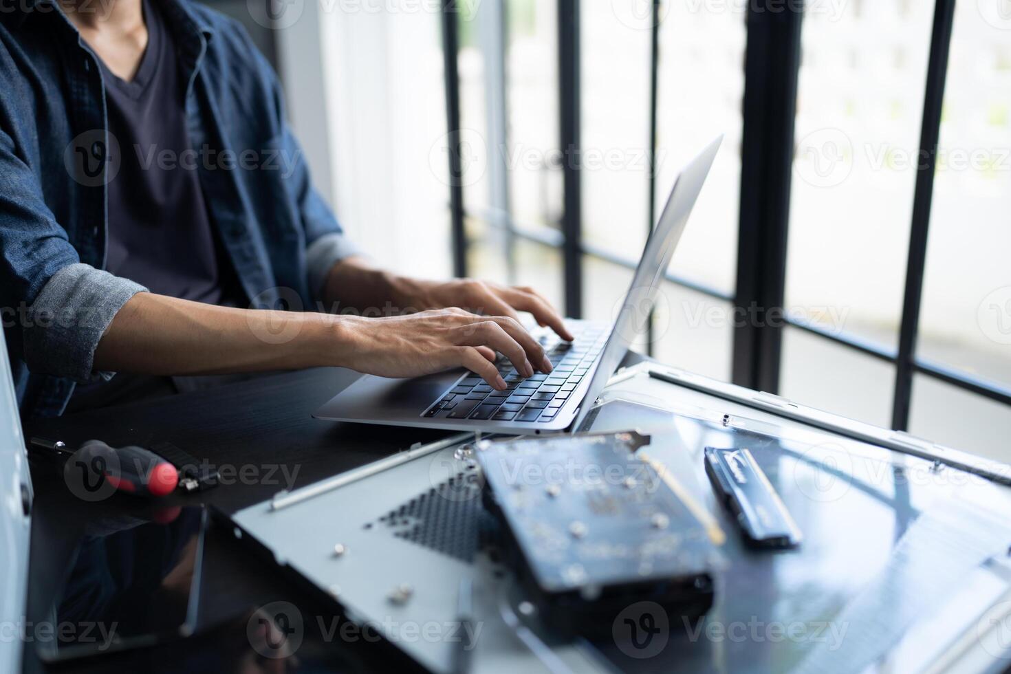a IT engneer is typing on a laptop computer photo