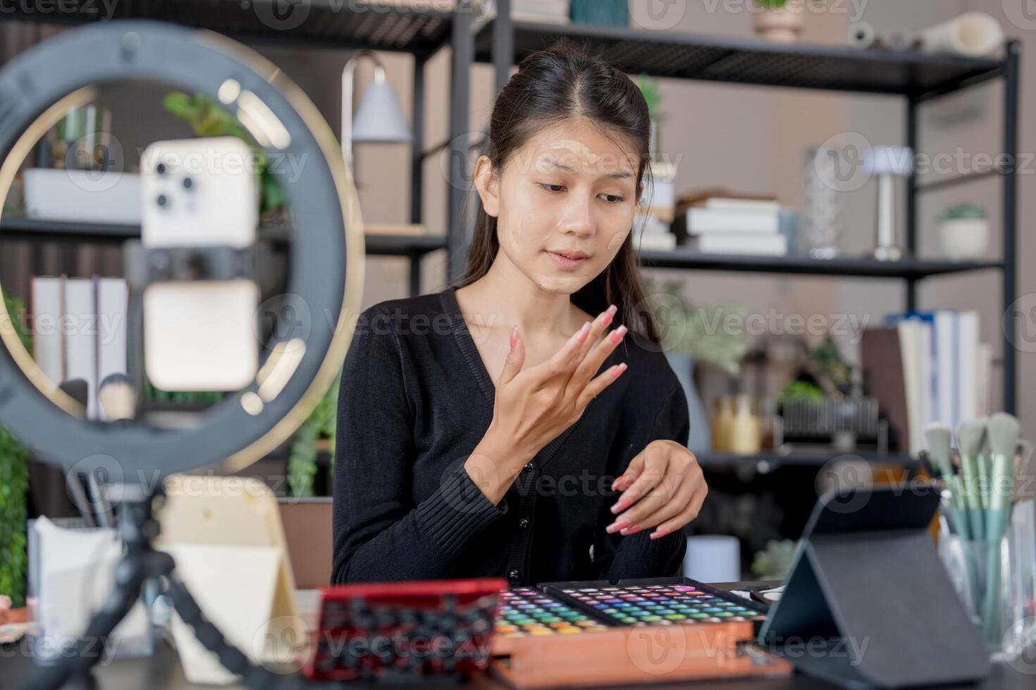 a woman sitting at a desk with a tablet and a camera photo