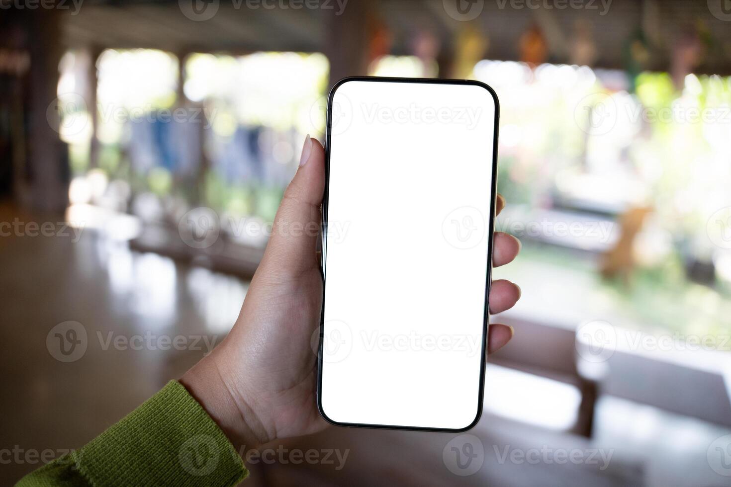a person holding up a blank white phone screen. photo