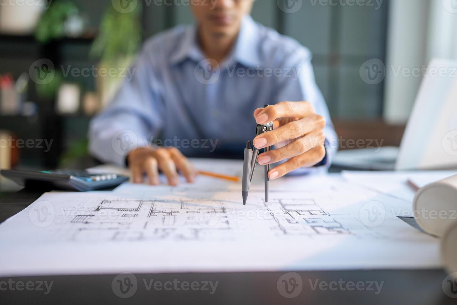 a man is working on a blueprint with a pencil. photo