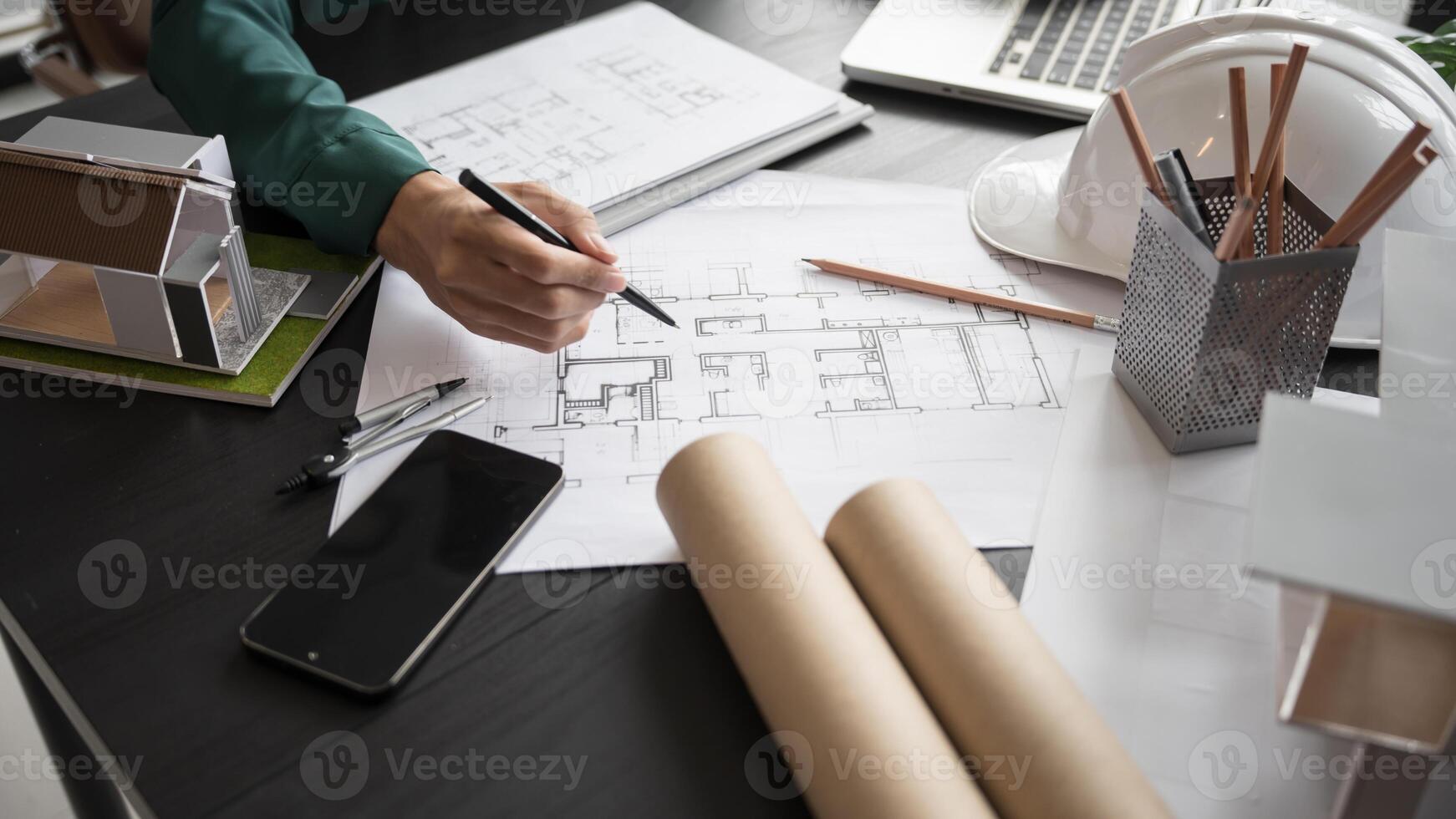 a person is working on a project with a laptop and a hardhat. photo