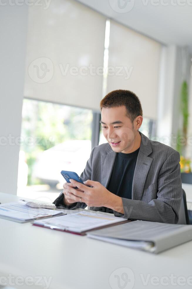 Asian Businessman with Smartphone working mobile devices cell telephone technology e-commerce smartphone business professional investor working new project photo