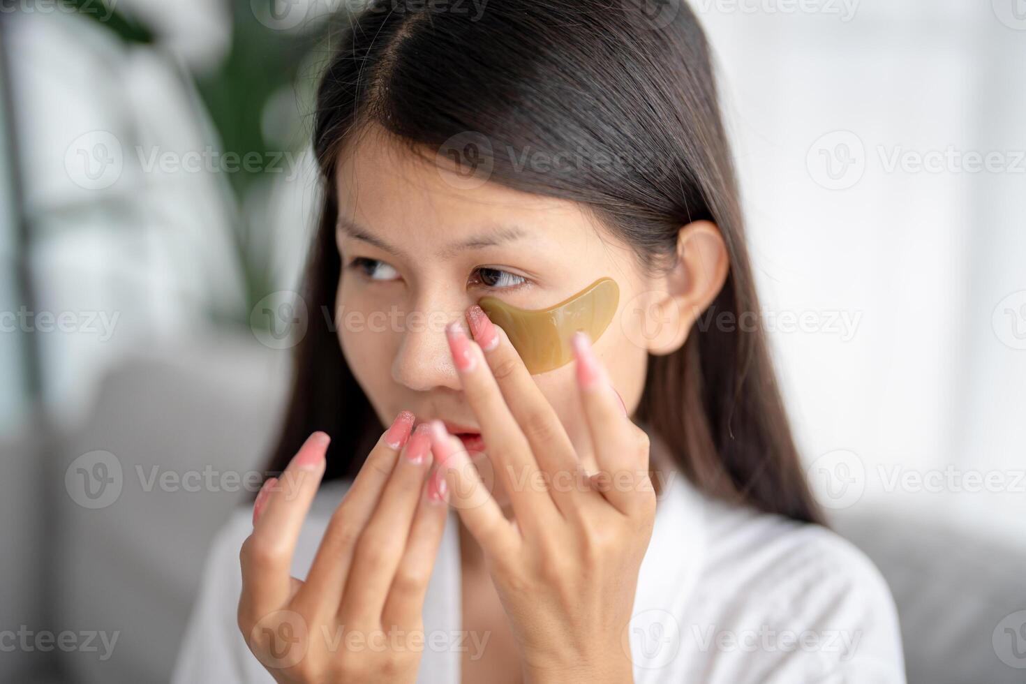 Daily beauty routine Asian woman self care and relax with silicone under eye patches smiling happy using skincare product. photo