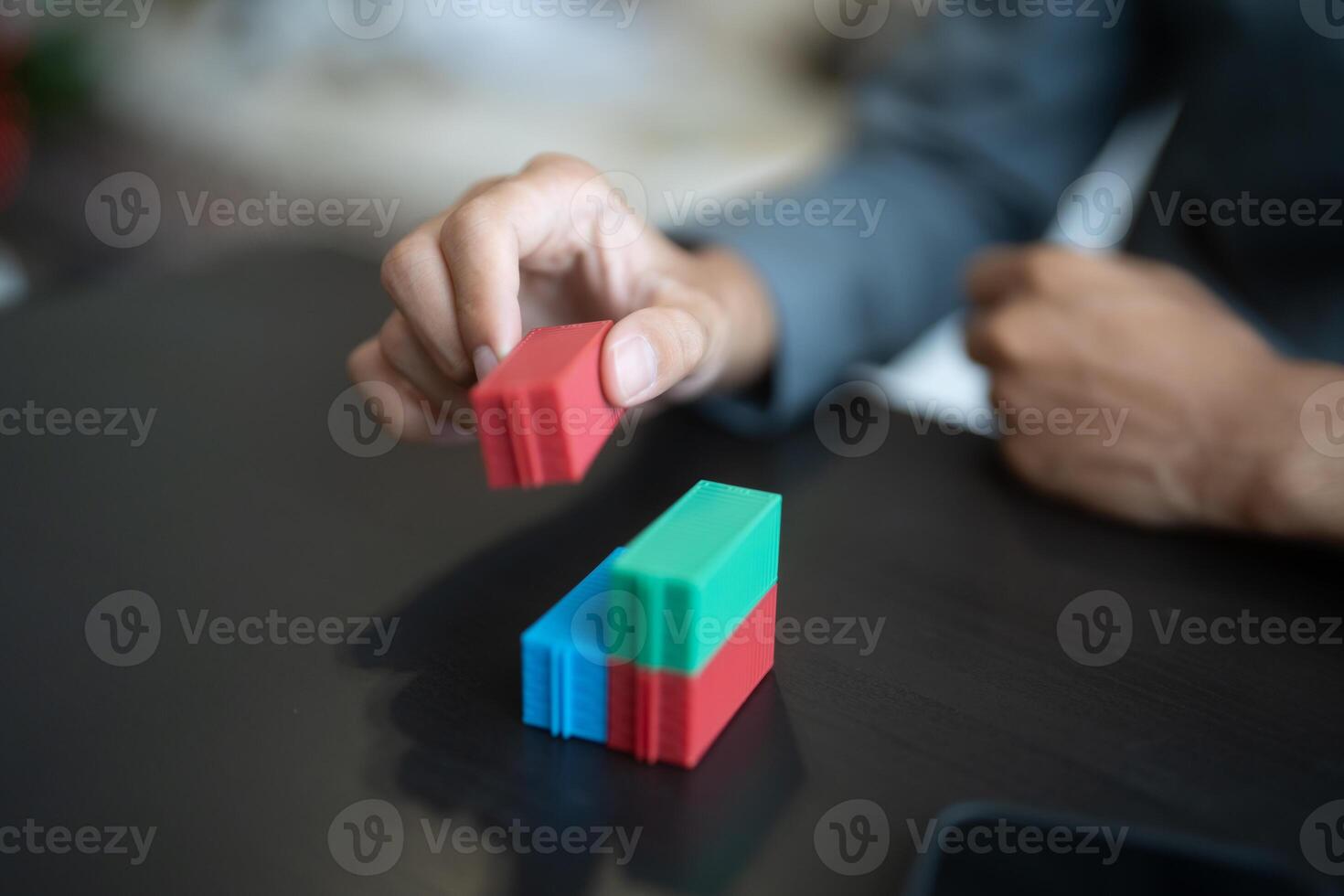 a person is placing blocks on a table Global Shipping Business cargo containers logistics photo