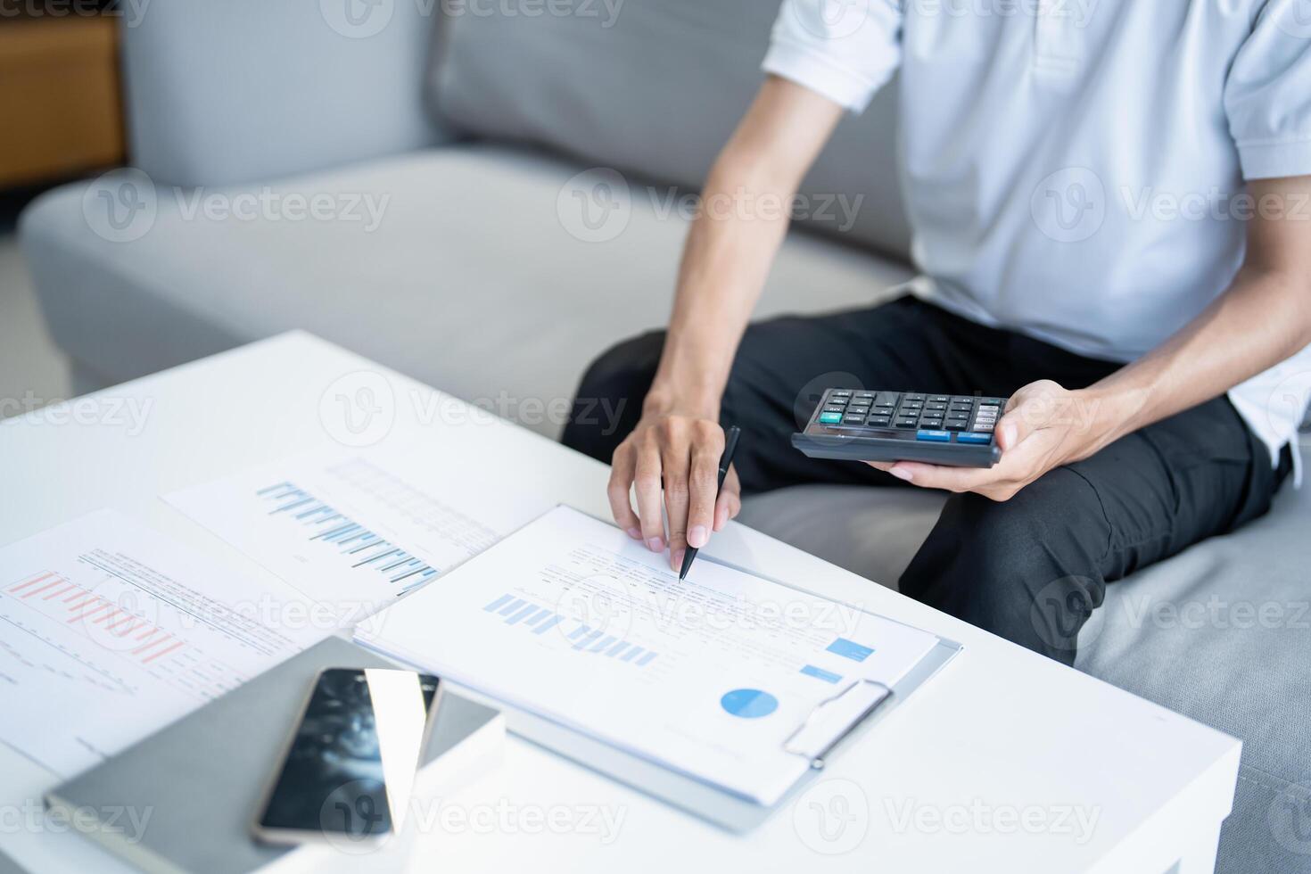 man using calculator and pen to calculate the financial situation photo